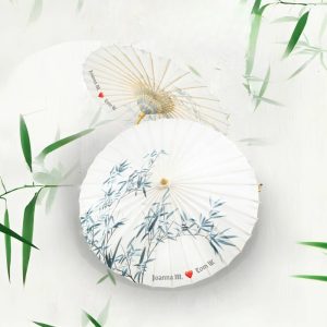 A romantic couple holding matching oil-paper umbrellas, showcasing traditional craftsmanship.